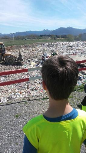 enfant au centre de tri de capvern devant les déchets enfouis